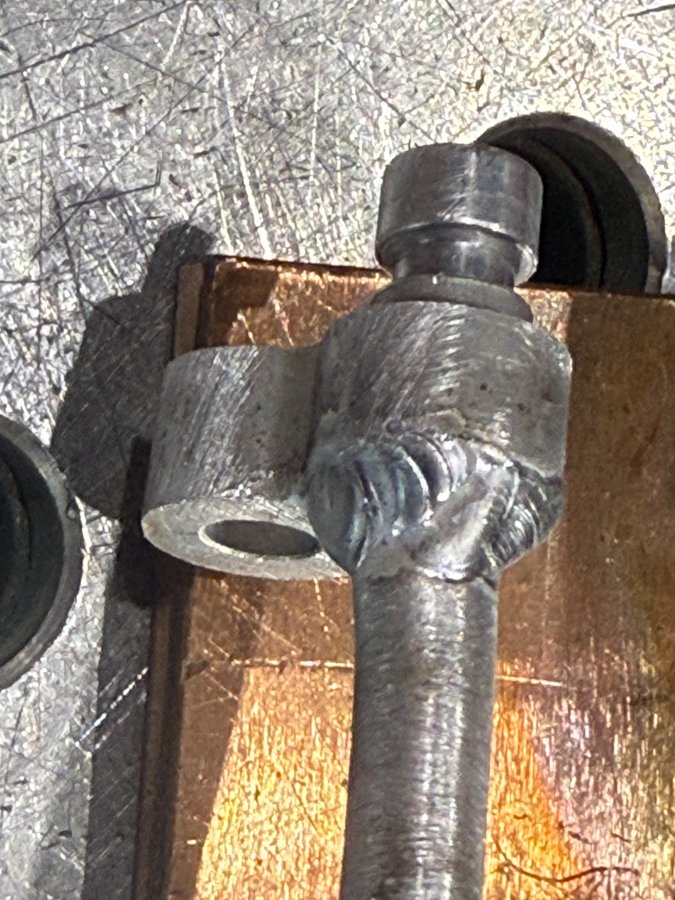 フランジ構造を持つアルミ配管分岐部を治具で固定し、位置ズレを抑えてTIG溶接している状況