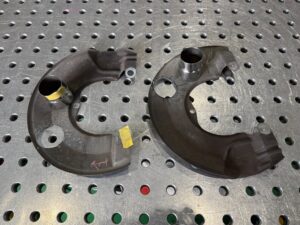 ランサーエボリューションX用ディスクブレーキダクトカバーを治具上で固定し、位置決めを行っている様子。精密な溶接準備工程。