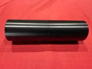 黒色の硬質アルマイト処理を施した円筒部品。MIL-A-8625 F-1 TYPEⅢ対応で高い耐摩耗性と精度を両立。