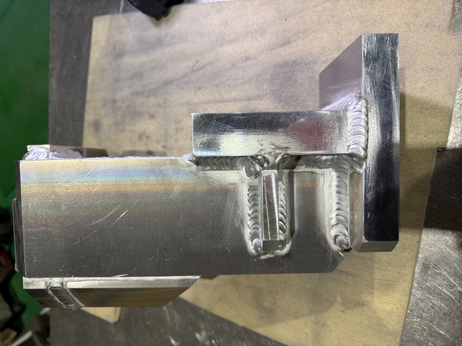 複雑形状のアルミ厚物部品に多方向からTIG溶接を施した組立品。精密な熱管理による溶接品質が特徴。